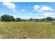 Beautiful grassy property featuring a long gravel driveway, outbuildings, and fenced perimeter at 2698 Sw 186Th Ct, Dunnellon, FL 34432