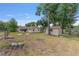 Large backyard featuring mature trees, a firepit, storage shed, and partial fencing at 2819 Ne 32Nd Pl, Ocala, FL 34479