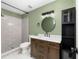 Updated bathroom featuring modern fixtures, a round mirror, stylish vanity, and walk-in shower at 2819 Ne 32Nd Pl, Ocala, FL 34479