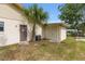 Back of cream colored home with a palm tree, storage shed, AC unit and a screen door for easy access at 2819 Ne 32Nd Pl, Ocala, FL 34479