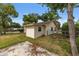 Side view of a cream colored home with a gated yard, manicured lawn, and a convenient driveway for easy access at 2819 Ne 32Nd Pl, Ocala, FL 34479