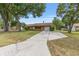 Residential home with mature shade trees and a long concrete driveway at 2819 Ne 32Nd Pl, Ocala, FL 34479