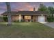 Charming brick home with a well-manicured lawn and attached one-car garage at sunset at 2819 Ne 32Nd Pl, Ocala, FL 34479