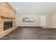 Bright living room with wood-look flooring, brick fireplace, and a view of the front yard at 2819 Ne 32Nd Pl, Ocala, FL 34479