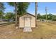 Exterior view of the home's matching storage shed with double doors, a wooden ramp and neutral color at 2819 Ne 32Nd Pl, Ocala, FL 34479
