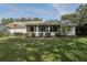 Wide backyard with patio, sunroom, and manicured lawn, perfect for relaxation and outdoor activities at 36 Gordon Ct, Leesburg, FL 34788