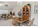 Cozy dining area featuring a wood table, chandelier, and a cabinet, with a living room visible in the background at 36 Gordon Ct, Leesburg, FL 34788