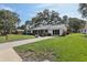 Charming single-story home with a well-manicured lawn, concrete driveway and mature trees at 36 Gordon Ct, Leesburg, FL 34788