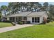 Charming single-story home with a well-manicured lawn and a screened in porch at 36 Gordon Ct, Leesburg, FL 34788