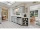 Charming kitchen with white appliances, light gray cabinets and a view to a cozy dining area at 36 Gordon Ct, Leesburg, FL 34788