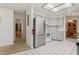 Bright kitchen featuring stainless steel refrigerator, white cabinets and appliances, and tiled flooring at 36 Gordon Ct, Leesburg, FL 34788
