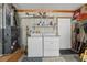 Bright laundry area with washer, dryer, storage shelves, and stylish wood paneling at 36 Gordon Ct, Leesburg, FL 34788