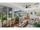 Bright sunroom with a ceiling fan, large windows and a seating area overlooking the outdoor scenery at 36 Gordon Ct, Leesburg, FL 34788