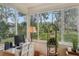Bright sunroom featuring a workspace, large windows, and a view of the surrounding greenery at 36 Gordon Ct, Leesburg, FL 34788