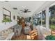 Cozy sunroom with white paneling, a floral sofa, lots of windows, and a view to the outdoors at 36 Gordon Ct, Leesburg, FL 34788