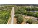 A high angle of a home with a red tile roof, next to a lush forest and quiet road at 361 Oak Lane Drive Dr, Ocala, FL 34472