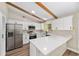 Bright kitchen featuring white cabinets, stainless steel appliances, a large island, and rustic beamed ceilings at 361 Oak Lane Drive Dr, Ocala, FL 34472