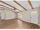 Bright living room featuring wood-look flooring, beamed ceilings, and natural light from a window and glass paneled entry door at 361 Oak Lane Drive Dr, Ocala, FL 34472