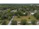Aerial view of the land that surrounds a small house, lush green grass, and mature trees at 3800 Ne 24Th Ct, Ocala, FL 34479