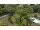 Aerial view of a home amidst mature trees, highlighting the property's serene and private setting at 3800 Ne 24Th Ct, Ocala, FL 34479