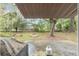 View of the backyard featuring a covered patio, trees, and a fire pit at 3800 Ne 24Th Ct, Ocala, FL 34479