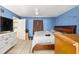 Cozy bedroom with blue walls, wood furniture, and a ceiling fan, illuminated by natural light at 3800 Ne 24Th Ct, Ocala, FL 34479