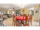 Open dining area with a red tablecloth, chandelier lighting, and seamless flow into the living room at 3800 Ne 24Th Ct, Ocala, FL 34479