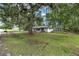 Charming house with a lush, grassy yard, large trees, shed, and front yard tree house at 3800 Ne 24Th Ct, Ocala, FL 34479
