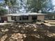 Charming single story home featuring a neutral exterior, shuttered windows, and mature shade trees at 3800 Ne 24Th Ct, Ocala, FL 34479