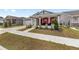 Attractive residence featuring a two-car garage, red shutters, covered porch, and green lawn at 6486 Sw 75Th Avenue Rd, Ocala, FL 34474