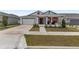 Beautiful house featuring a two-car garage, red door, covered porch and well-kept front yard at 6486 Sw 75Th Avenue Rd, Ocala, FL 34474