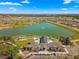 A captivating aerial shot of a community, clubhouse, lake with lush landscaping and a golf course at 6984 Sw 94Th Ct, Ocala, FL 34481