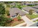 An aerial view shows a well-maintained home with a two-car garage and long driveway, surrounded by lush greenery at 6984 Sw 94Th Ct, Ocala, FL 34481