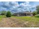 Expansive backyard featuring a screened-in pool area, lush lawn, and mature landscaping at 6984 Sw 94Th Ct, Ocala, FL 34481