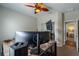 Bedroom with a ceiling fan, a large monitor on a desk, and a doorway to another room at 6984 Sw 94Th Ct, Ocala, FL 34481
