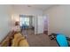 Bedroom featuring a bench, a large mirror, a doorway to another room, and a unique yellow loveseat at 6984 Sw 94Th Ct, Ocala, FL 34481