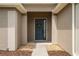 Up-close entrance featuring a welcoming front door with decorative wreath and carefully-placed landscaping at 6984 Sw 94Th Ct, Ocala, FL 34481