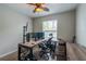 A well-lit home office with modern desk setup, comfortable chair, and ample natural light at 6984 Sw 94Th Ct, Ocala, FL 34481