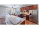 Kitchen with stainless steel appliances, dark cabinets, a breakfast bar, and a view of the lanai at 6984 Sw 94Th Ct, Ocala, FL 34481