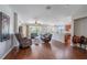 Open concept living room featuring hardwood floors, ceiling fans, and clear views of the outdoor pool at 6984 Sw 94Th Ct, Ocala, FL 34481