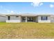 Large backyard showcasing the covered patio and the home's design with expansive lawn at 7638 Sw 60Th St, Ocala, FL 34474