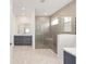 Modern bathroom featuring gray cabinets, dual sinks, a glass-enclosed shower, and stone-look shower floor at 7638 Sw 60Th St, Ocala, FL 34474