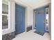 Covered entry with double blue doors and stone accents; Calesa doormat on a concrete floor at 7638 Sw 60Th St, Ocala, FL 34474