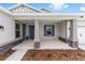 Inviting front porch with stone columns and trim details, blue door and manicured landscaping at 7638 Sw 60Th St, Ocala, FL 34474