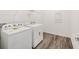 Well-lit laundry room featuring a Whirlpool washer and dryer, and sleek gray-toned hardwood floors at 7638 Sw 60Th St, Ocala, FL 34474