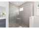 Modern tiled shower with glass door and accent stone flooring at 7638 Sw 60Th St, Ocala, FL 34474