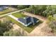 An aerial view of a modern home with a long driveway and wooded perimeter at 8200 Sw 125Th Court Rd, Dunnellon, FL 34432