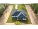 An aerial view of a modern home showing lawn, new driveway, and elegant roof at 8200 Sw 125Th Court Rd, Dunnellon, FL 34432