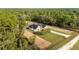 An aerial view of a modern home in a wooded lot with a long driveway at 8200 Sw 125Th Court Rd, Dunnellon, FL 34432