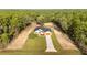 Aerial view of a single-story home nestled among trees, featuring a spacious yard and long driveway at 8200 Sw 125Th Court Rd, Dunnellon, FL 34432